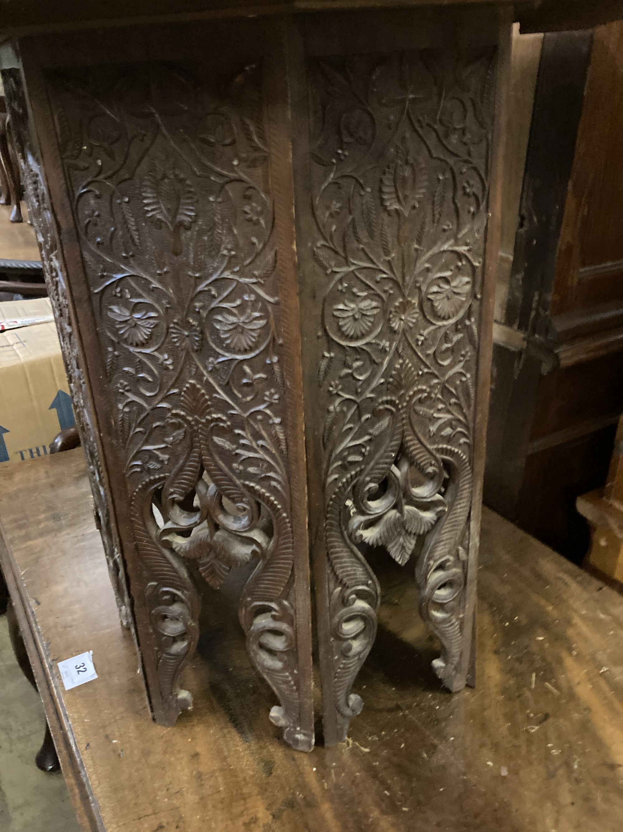 An Indian carved hardwood coffee table on a folding stand, width 63cm height 60cm